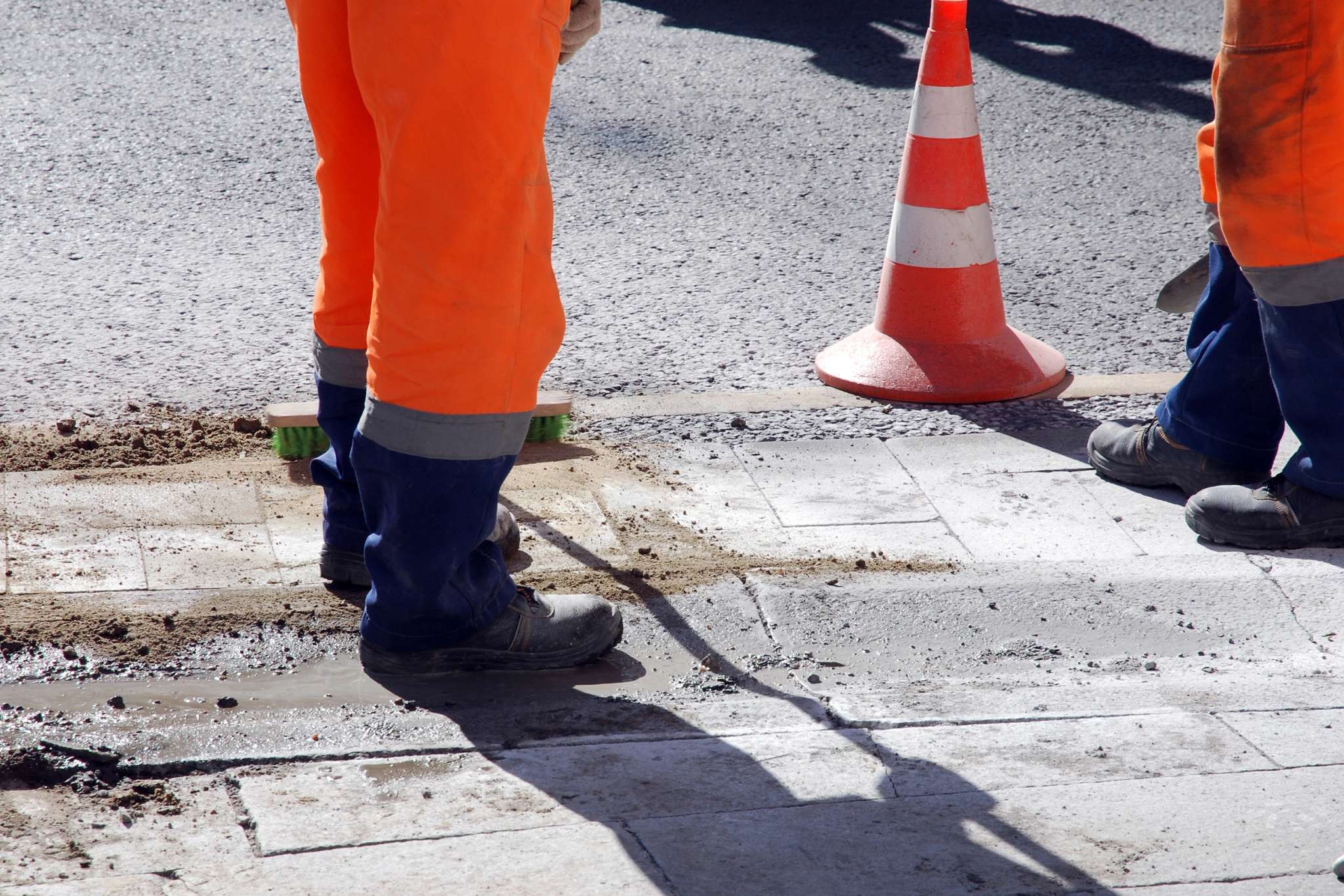 Ouvriers en gilets orange et cônes de signalisation sur chantier routier